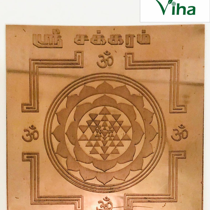 Sri Chakra Yantram, a square, copper-colored metallic plate with an etched central lotus and geometric pattern, surrounded by four symbols and Tamil script