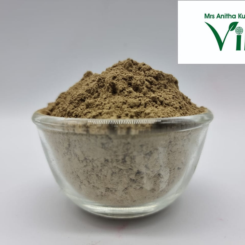 Vallarai Powder / Brahmi Powder, a small clear glass bowl containing a mounded heap of fine, matte brown powder against a plain background