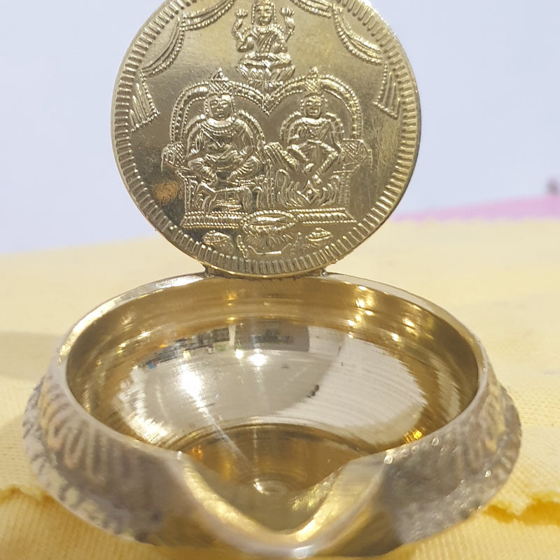 Lakshmi Kuber vilakku in brass, embossed Lakshmi and Kubera coin plaque behind a deep oil bowl