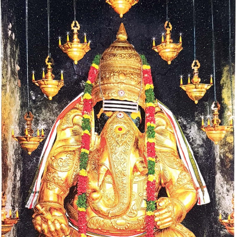 Pillaiyar Patti Photo, a gold-toned, seated sculpture with eight hanging lamps and two red-and-green floral garlands on a dark, speckled background