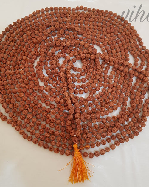 5 Face Rudraksh Japa Mala, a coiled loop of rough brown beads ending in an orange tassel