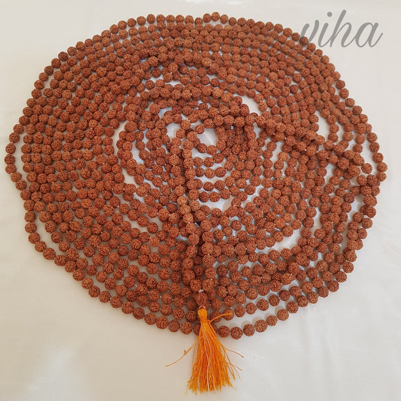5 Face Rudraksh Japa Mala, a coiled loop of rough brown beads ending in an orange tassel