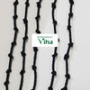 Drishti removing black thread (drishti kayiru, karuppu kayiru), five black knotted cords on a white surface