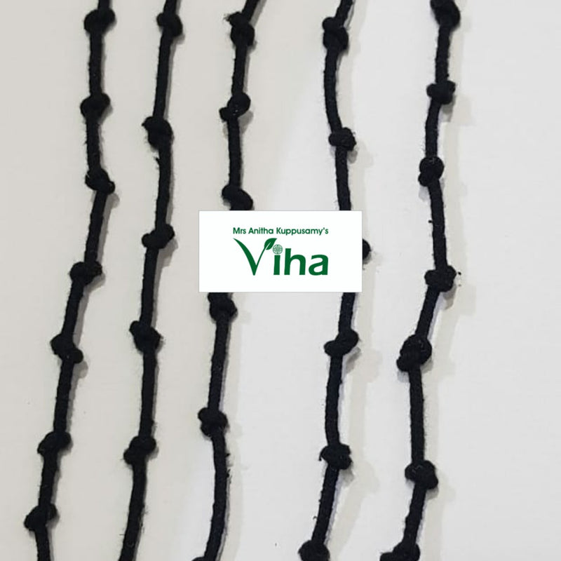Drishti removing black thread (drishti kayiru, karuppu kayiru), five black knotted cords on a white surface