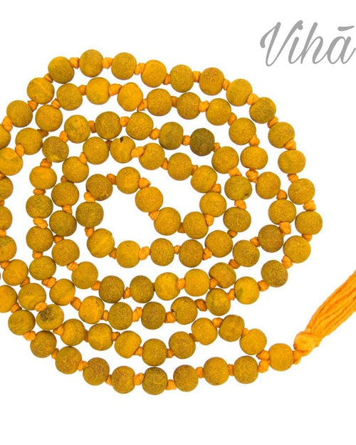 Haldi Mala / Turmeric Mala, a long strand of matte yellow beads, threaded and knotted together with orange string, terminating in an orange tassel