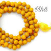 Haldi Mala / Turmeric Mala, a yellow beaded necklace with an orange string and a yellow tassel attached to the right side