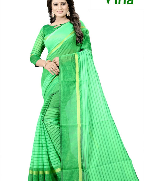 Soft Cotton Saree, a smiling woman in a lime green sari with faint dark stripes and a matching blouse, wearing gold-toned earrings and bangles