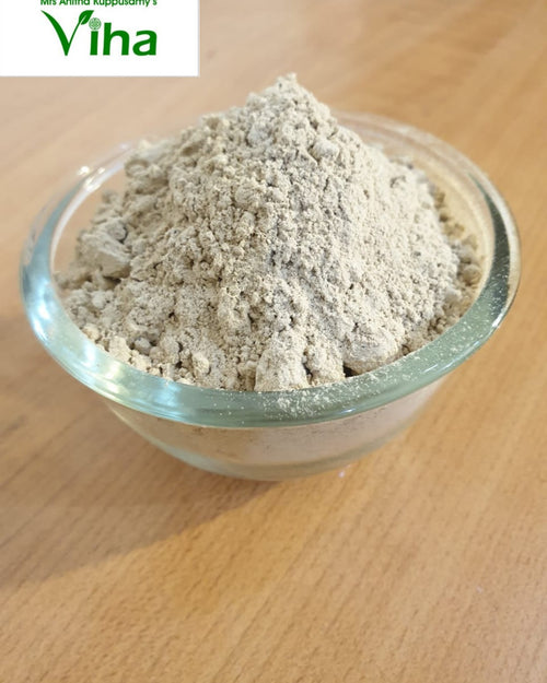 Ashwagandha Powder, a clear glass bowl filled with grayish powder sits on a wooden surface