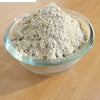 Ashwagandha Powder, a clear glass bowl filled with grayish powder sits on a wooden surface