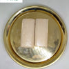 Gopi Chandan, two beige rectangular bars wrapped in clear film lying on a round gold-toned tray