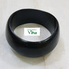 Karungali Wood Bangle, a thick black matte bangle with a slightly irregular rounded shape resting on a tiled surface