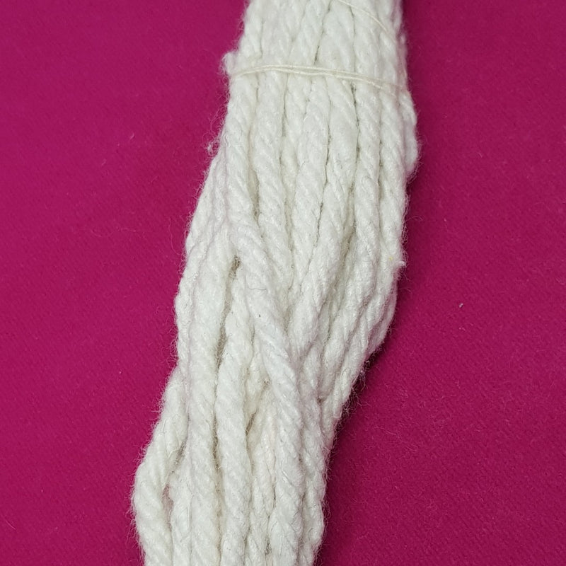 A single long twisted white cotton wick strand on a magenta cloth