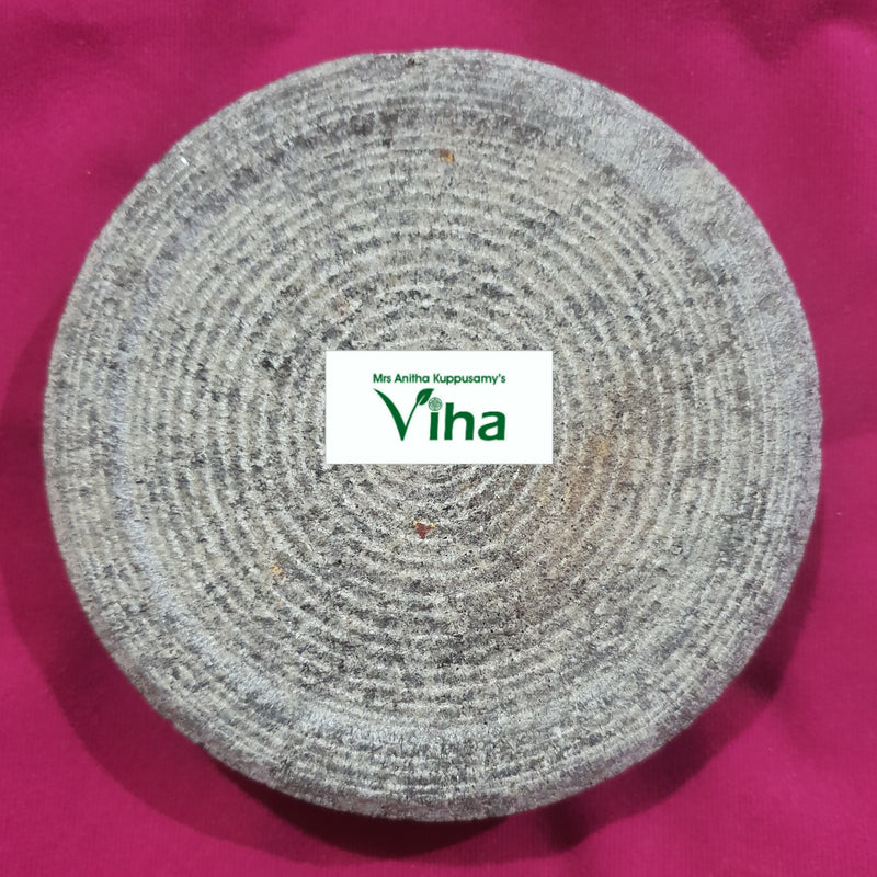 Turmeric Rubbing Stone, a grey textured circular flat stone object featuring multiple concentric grooved circular lines across its surface