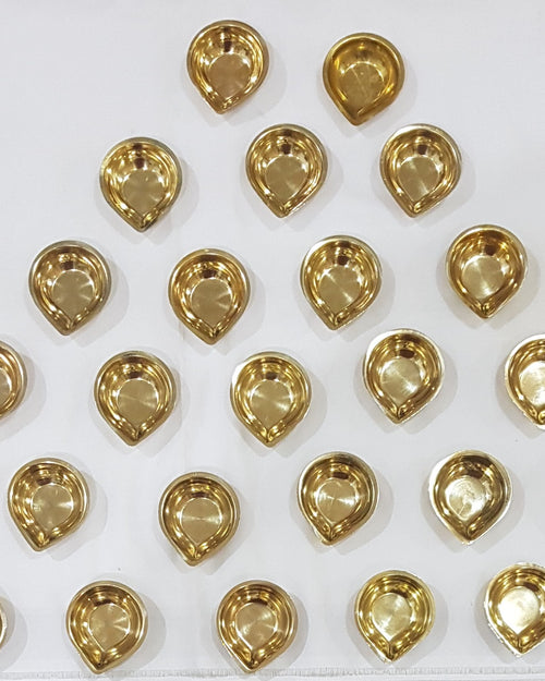 Set of 27 brass karthigai vilakku, small teardrop agal lamps arranged in rows