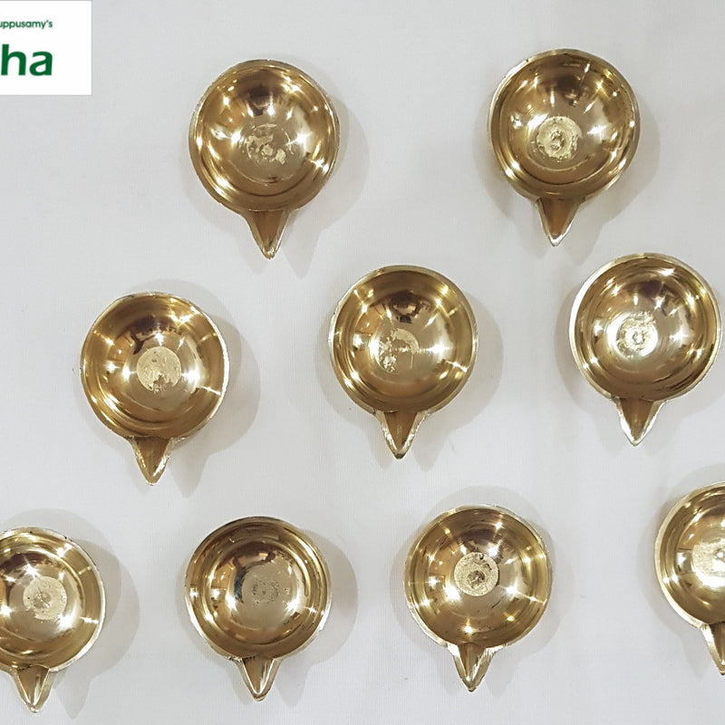 Set of premium brass Mahalakshmi pooja lamps, eleven small footed agal lamps laid out in rows
