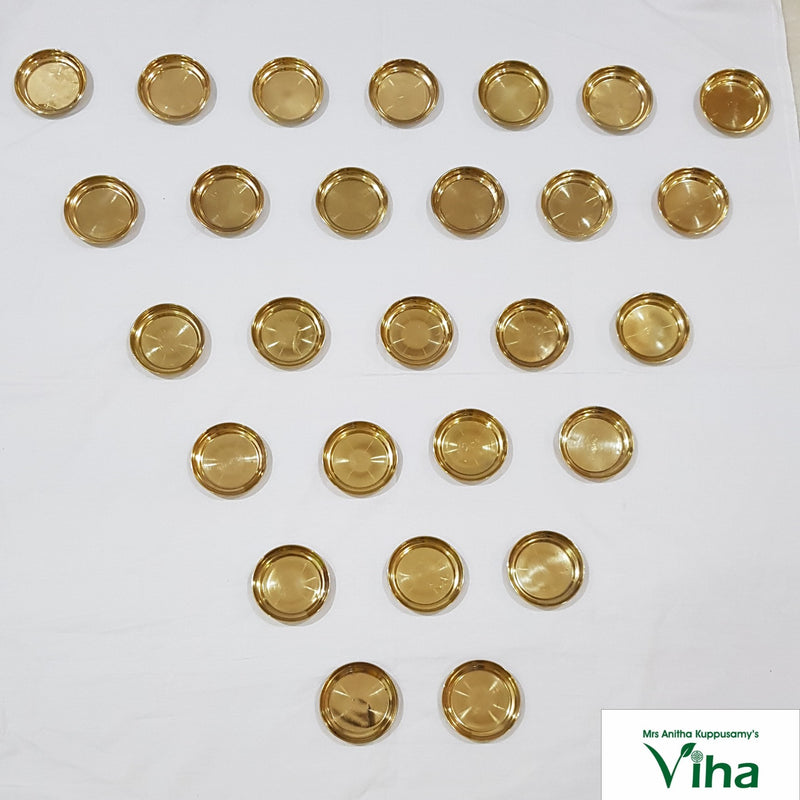 Set of 27 brass vilakku plates, small round lamp plates laid out in rows