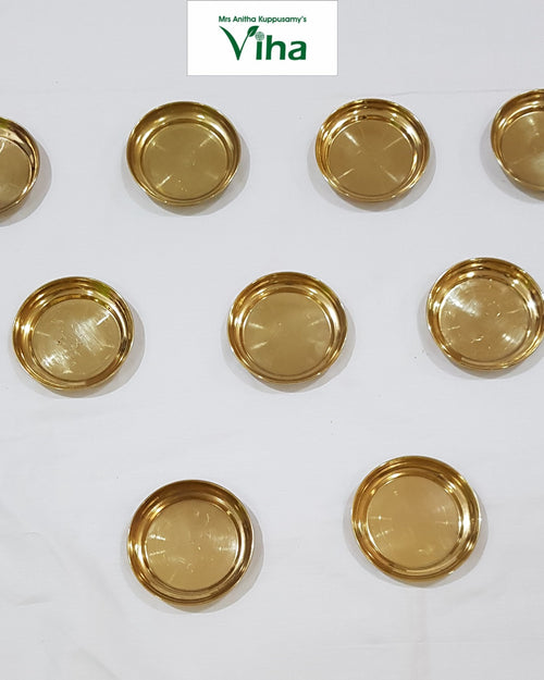 Set of 9 brass vilakku plates, small round lamp plates laid out in rows