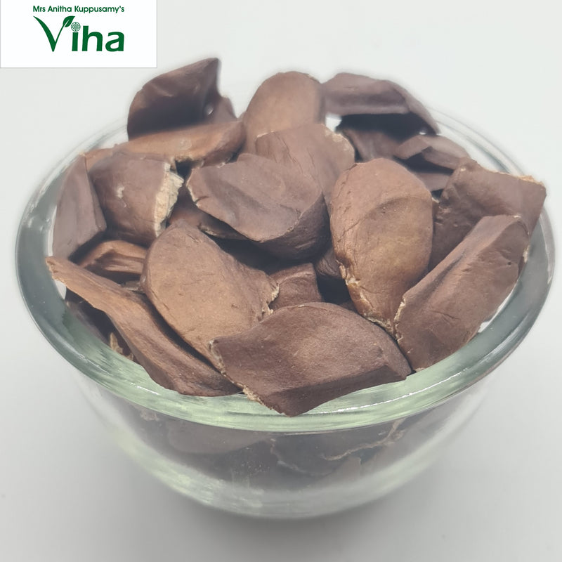 Thaen Kai, a transparent glass bowl filled with numerous flat, brown, irregular shaped pieces with matte finish showing light edges