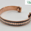 Copper Bracelet With Magnet, a copper-toned cuff bracelet with a central wave pattern and two silver-toned braided wires, featuring two round magnets