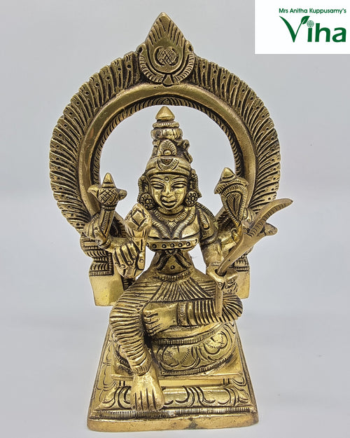 Sri Raja Rajeswari Amman in brass, seated figure beneath a large arch on a stepped base