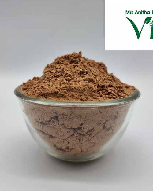 Sitharathai Powder / Kulanjan Powder, a clear glass round bowl filled with a brown fine powder against a light grey background