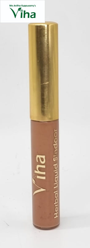 Sandalwood Liquid Sindoor, a round container with a shiny gold-toned cap and a matte tan body featuring white printed text
