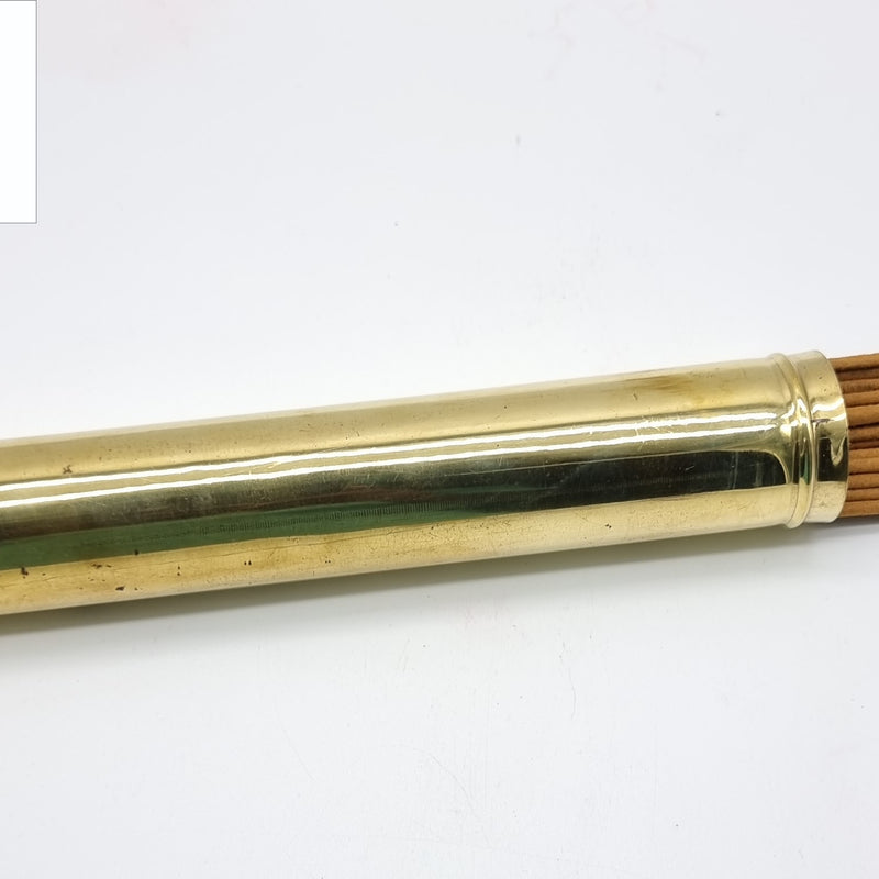 Agarbathi Storage Brass Container, a glossy gold-toned container holding many thin brown sticks poking out of one end