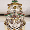 Amman Face Decorated With Jewels, a silver-toned face mask with gold-toned details, colored stones, and black beads on a gold-toned pot