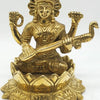 Saraswathi in brass, four-armed figure with a rayed halo seated on a wide lotus base with a veena and a peacock