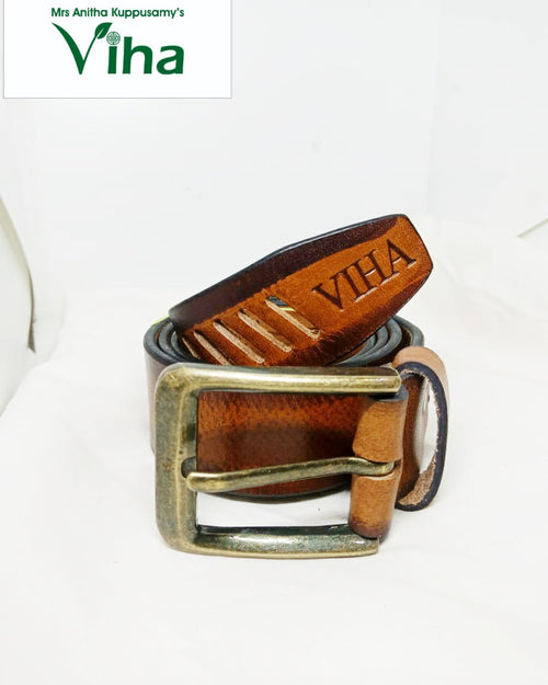 Viha Men's Leather Belt, a coiled brown belt with a metallic brass-toned buckle featuring text and decorative cutouts