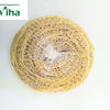 Vetiver Scrub / Vettiver, a round, pale yellow fibrous pad is enclosed in a white net mesh wrapper centered on a plain white surface