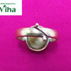 Gomathi Chakra Brass Ring - Women, a metallic-looking adjustable ring with a brownish oval center stone on a magenta background