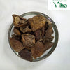 Brinjal Fryums, a top-down view of twelve brown wrinkled dried fruit pieces in a clear glass bowl against a white background