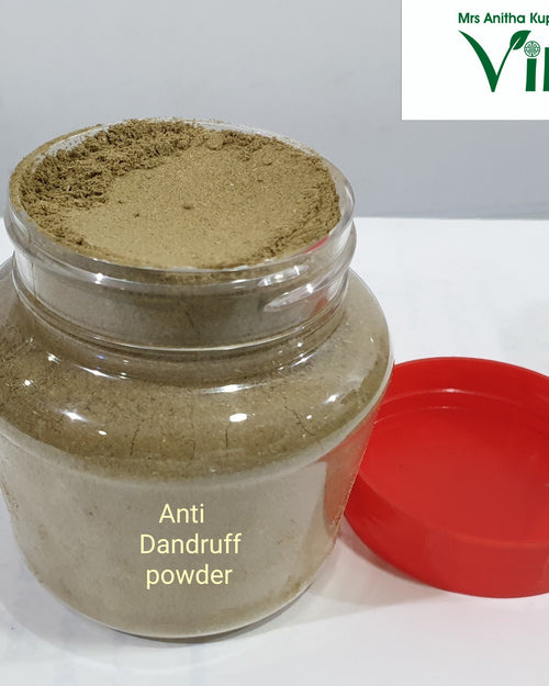 Anti Dandruff Powder, a transparent plastic jar containing brownish-green powder, featuring a label and accompanied by a detached red lid