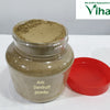 Anti Dandruff Powder, a transparent plastic jar containing brownish-green powder, featuring a label and accompanied by a detached red lid