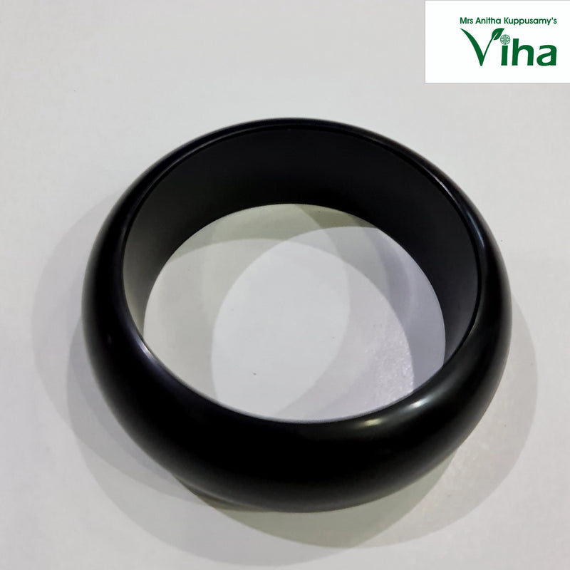 Karungali Wood Bangle, a thick, smooth black circular bangle with a rounded, glossy surface resting on a light grey background