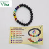 Bracelet of black beads with seven colored gemstone beads, next to a chakra mantra card