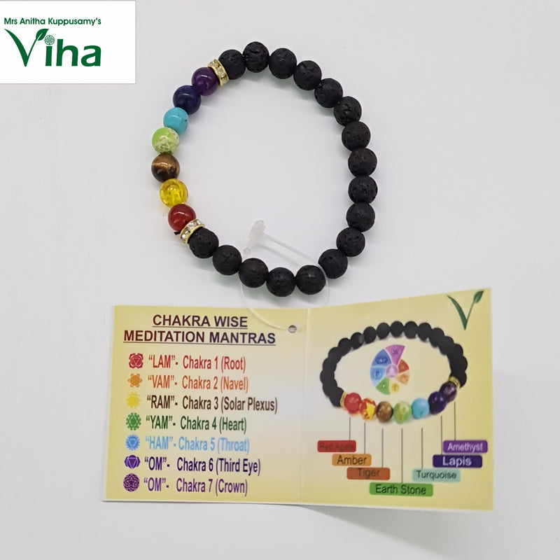 Bracelet of black beads with seven colored gemstone beads, next to a chakra mantra card