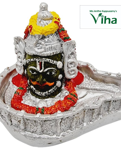 Maha Kala Bhairavar, dark painted face in relief garlanded at the head of a silver-toned shallow dish