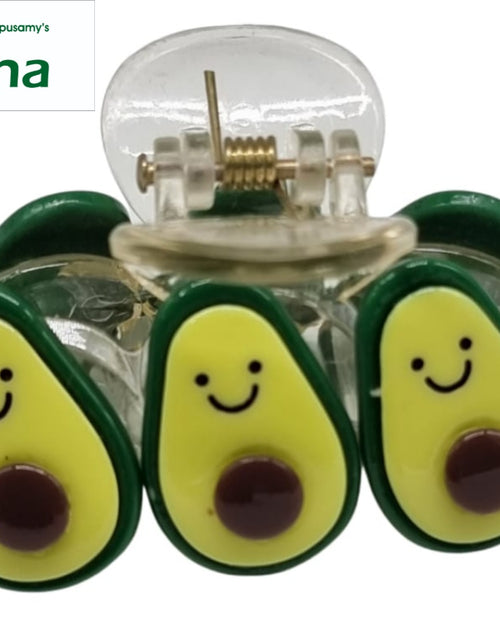 Premium Quality Strong Hair Clip, a clear claw clip features three green, yellow, and brown avocado shaped charms with smiling faces on the front