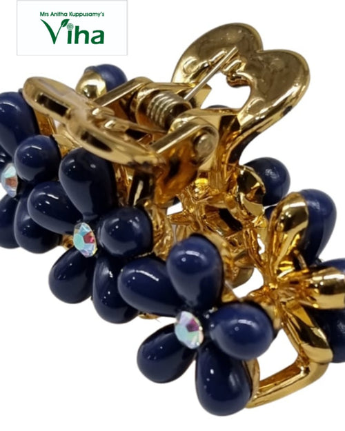Designer Hair Clip, a shiny gold-toned metal claw clip decorated with glossy dark blue flower shapes featuring central clear stones
