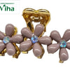 Designer Hair Clip, a gold-toned claw clip adorned with three glossy grey-brown flowers featuring iridescent central stones