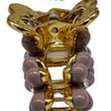 Designer Hair Clip, a gold-toned claw clip adorned with mauve-coloured rounded elements and clear iridescent stones