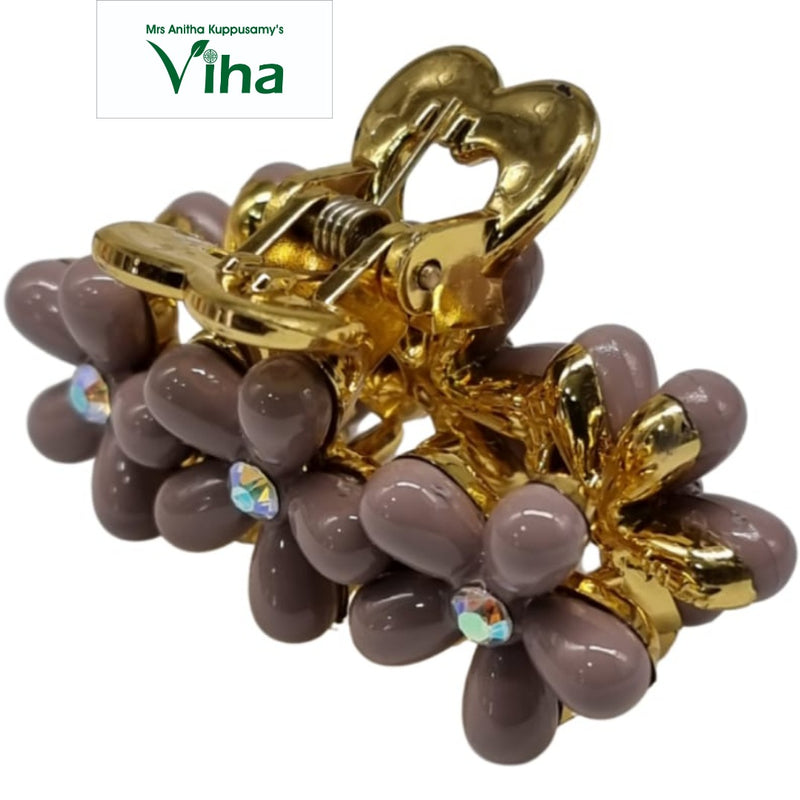 Designer Hair Clip, a shiny gold-toned claw clasp with mauve flower-shaped petals and iridescent center stones