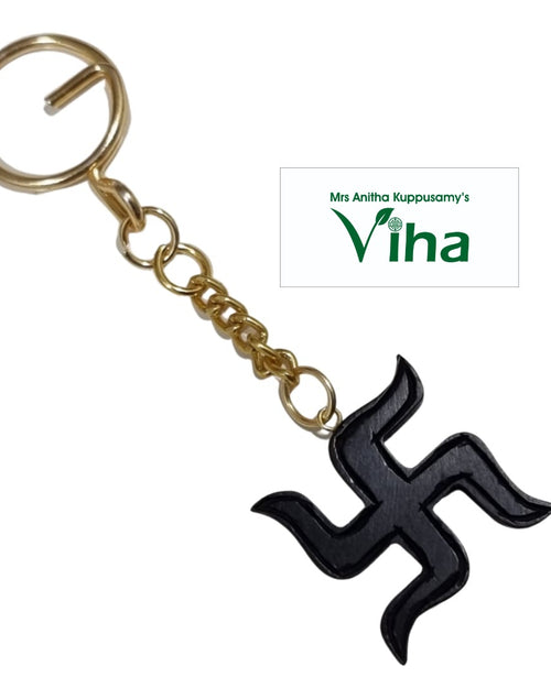 Karungali Swastik Keychain / Karungali Kattai Swastik Keychain, a gold-toned ring and chain attached to a black swastika charm
