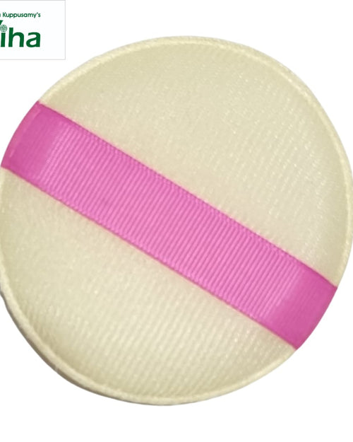 Powder Puff, a round cream-textured disc features a diagonal pink grosgrain ribbon strap bisecting its surface