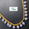 Impon Necklace, a curved gold-toned chain necklace features lavender-colored faceted beads dangling uniformly along its length
