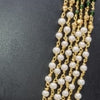 Aimpon Chain, five golden chains with green beads, white beads, and red beads on a black surface