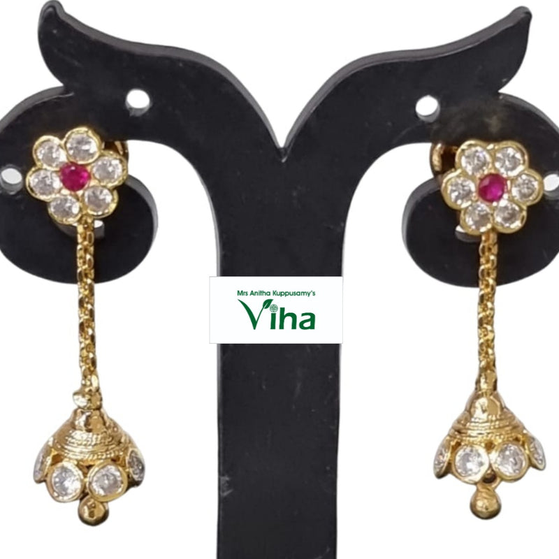 Aimpon Jhumkas, a pair of polished gold-toned earrings featuring flower studs with clear and pink stones, dangling chains, and bell-shaped jhumkas