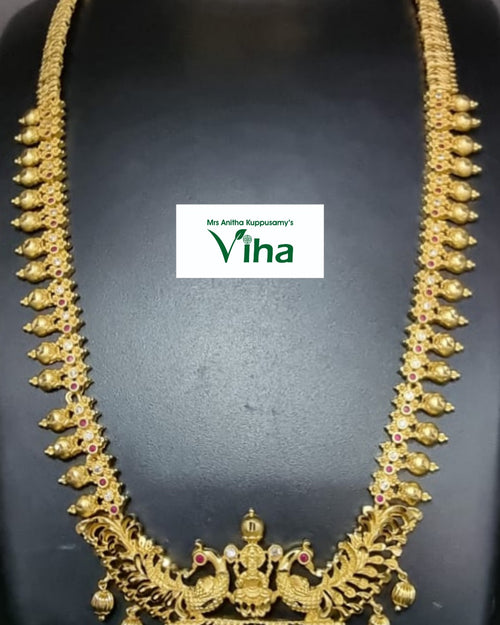 Aimpon Haram, a gold-toned necklace set with matching earrings features ornate filigree, clear stones, red stones, and dangling ball accents